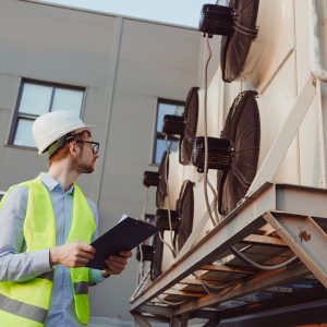 Service hvac engineer in uniform inspecting industrial refrigeration system