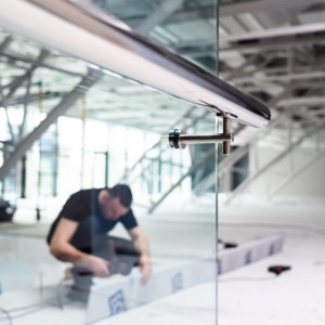 man-working-glass-wall-with-blue-sign-that-says-word-glass-it